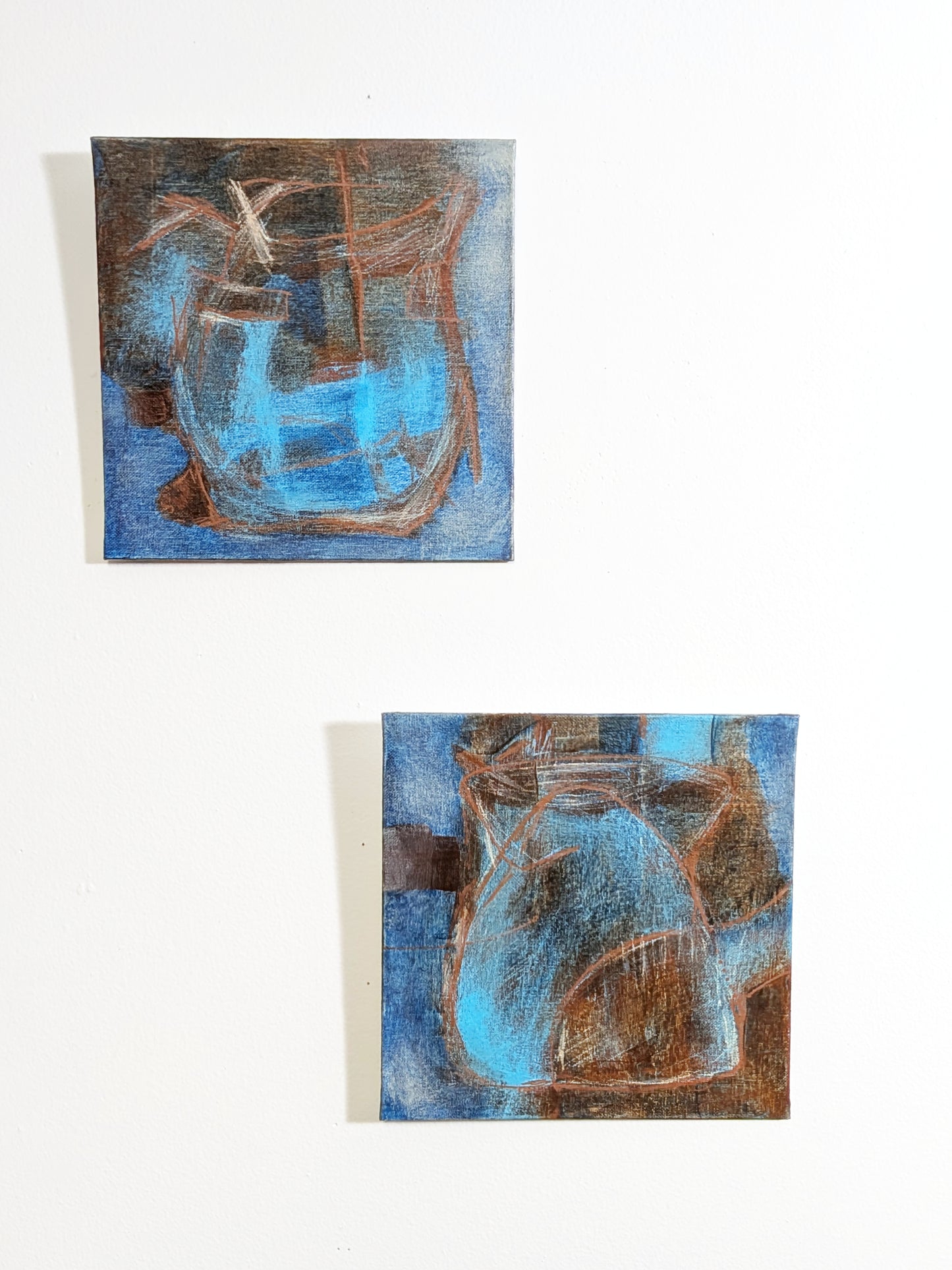 helen carter - 
Two small abstract paintings hanging on a white wall, each depicting a blue and brown pitcher or vase-like form with textured brushwork.